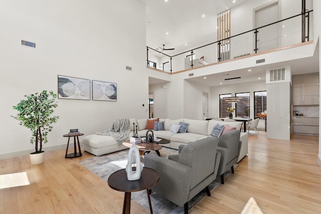 living room with a high ceiling and light hardwood / wood-style floors