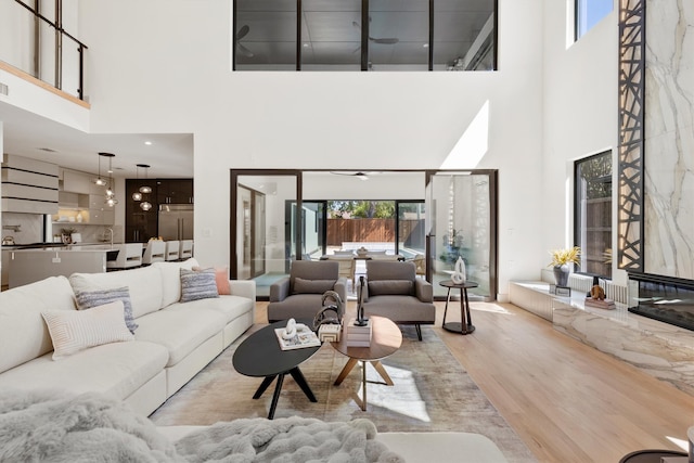 living room with light wood-type flooring and a high ceiling