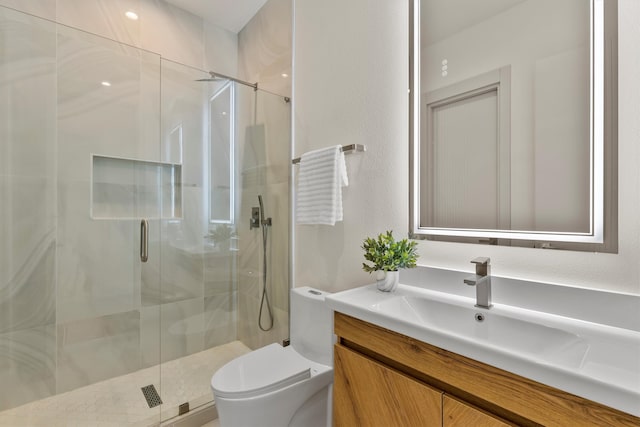 bathroom with vanity, a shower with shower door, and toilet