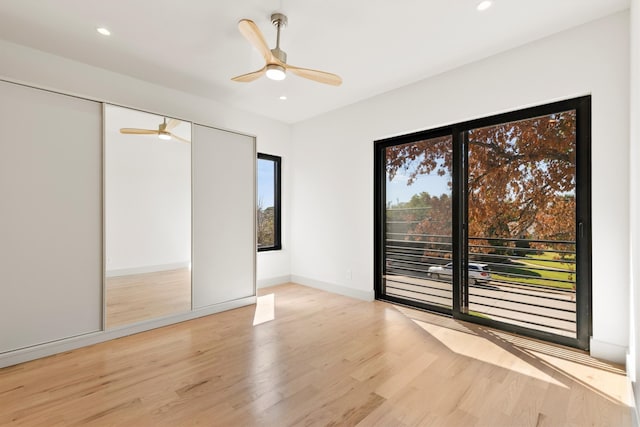 unfurnished bedroom featuring a closet, light hardwood / wood-style floors, and ceiling fan