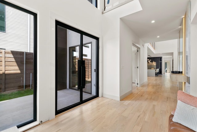 corridor with light wood-type flooring and plenty of natural light