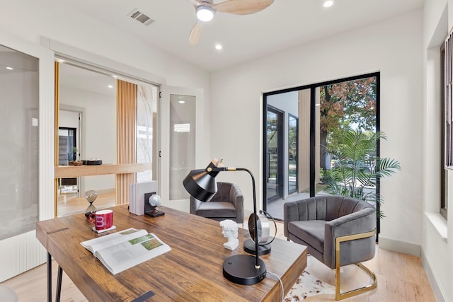 home office featuring ceiling fan, radiator, and light wood-type flooring