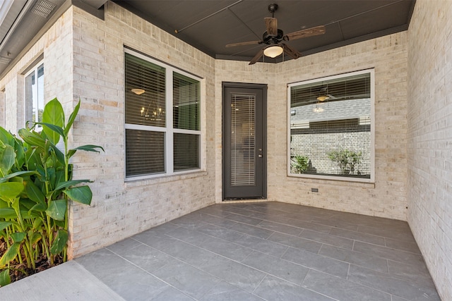 entrance to property with a patio area and ceiling fan