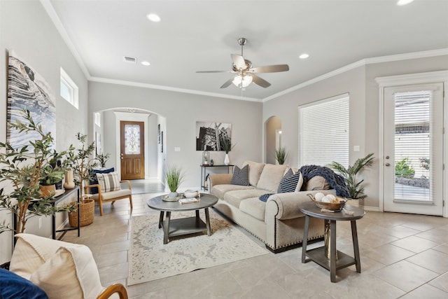 living room featuring ceiling fan, light tile patterned flooring, ornamental molding, and a wealth of natural light