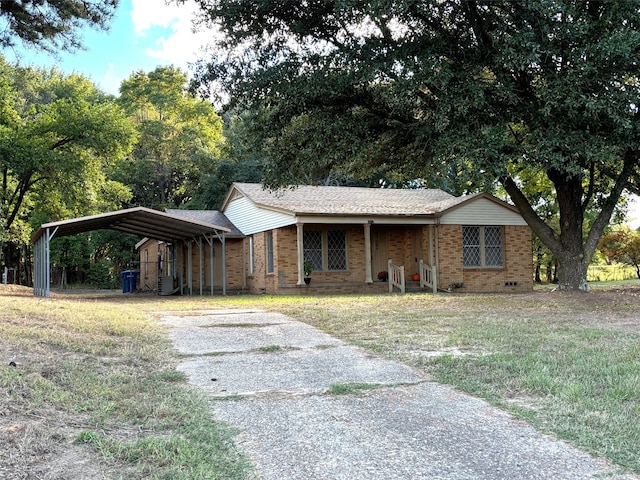 ranch-style house with a front yard, cooling unit, and a carport