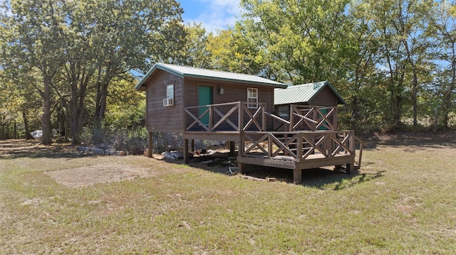 back of property with a wooden deck and a lawn