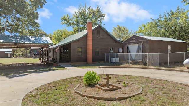 rear view of house with a carport, a yard, and a garage