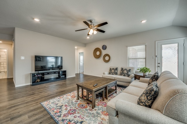 living room featuring lofted ceiling, ceiling fan, dark wood-type flooring, and a textured ceiling