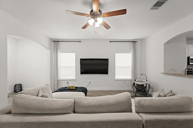 living room featuring ceiling fan, hardwood / wood-style flooring, and sink