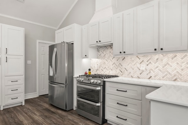 kitchen featuring lofted ceiling, white cabinetry, appliances with stainless steel finishes, crown molding, and dark hardwood / wood-style flooring