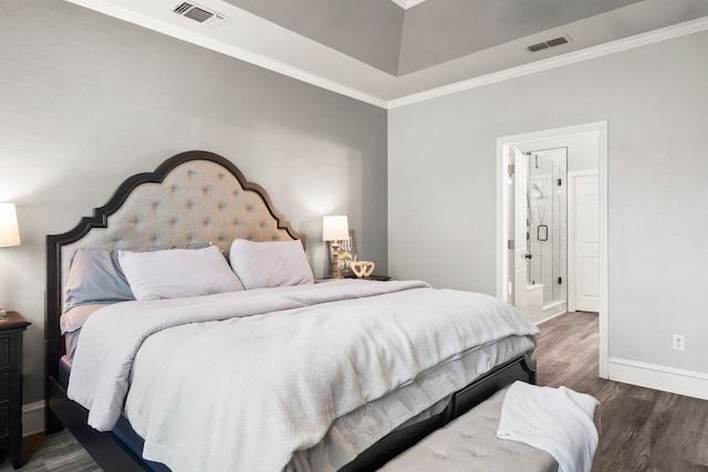 bedroom with ensuite bath, crown molding, and dark hardwood / wood-style flooring