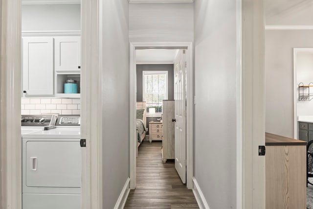 hallway with ornamental molding, dark wood-type flooring, and washing machine and clothes dryer