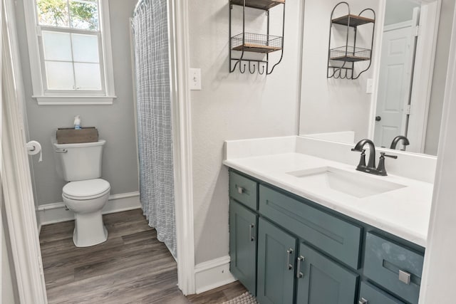 bathroom featuring wood-type flooring, vanity, and toilet