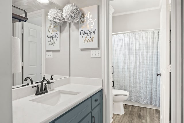 bathroom with vanity, crown molding, toilet, and hardwood / wood-style flooring