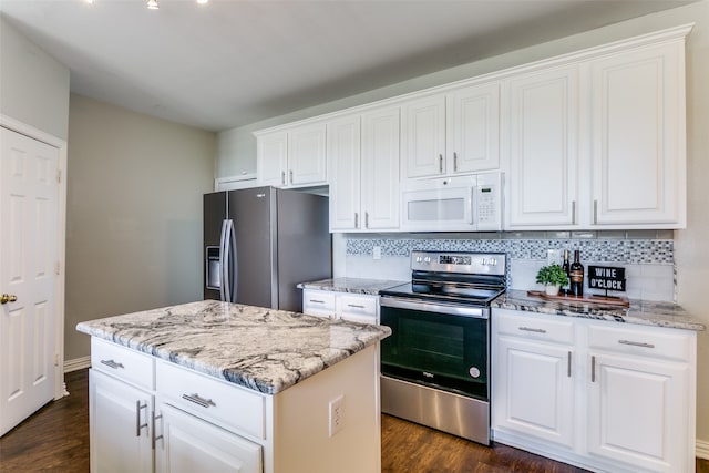 kitchen with white cabinets, stainless steel appliances, dark hardwood / wood-style flooring, and a center island