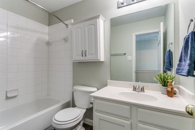 full bathroom with tiled shower / bath, vanity, and toilet