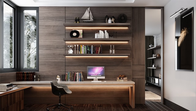 interior space featuring built in desk, dark wood-type flooring, and a healthy amount of sunlight