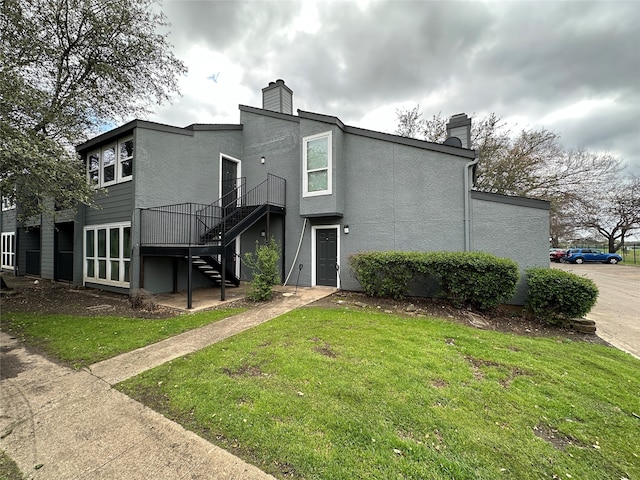 rear view of property featuring a lawn