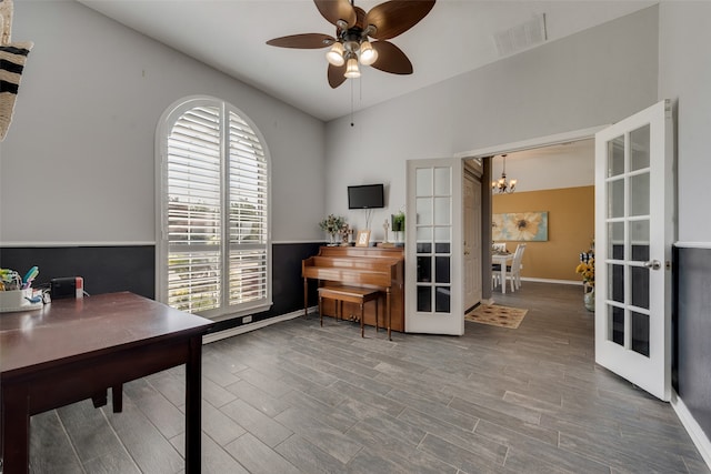 home office featuring ceiling fan with notable chandelier and wood-type flooring