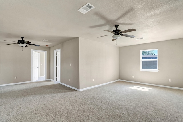 carpeted spare room featuring ceiling fan and a textured ceiling