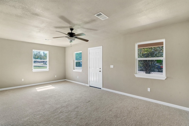 empty room with ceiling fan, a textured ceiling, and carpet flooring