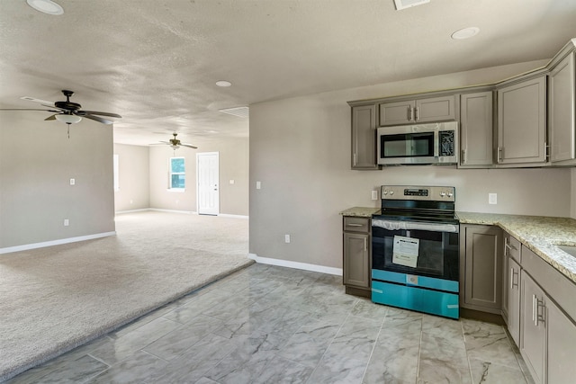 kitchen featuring ceiling fan, gray cabinets, stainless steel appliances, and light carpet