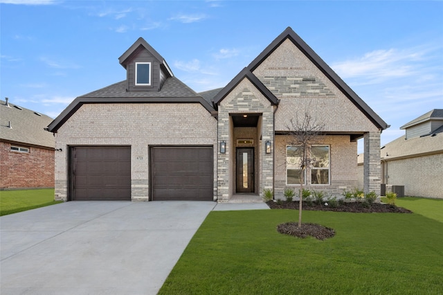 view of front of home with a garage, central air condition unit, and a front lawn