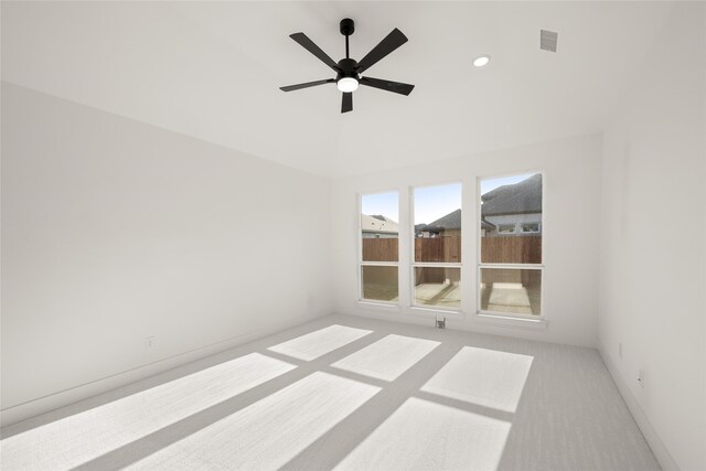 spare room featuring light carpet and ceiling fan