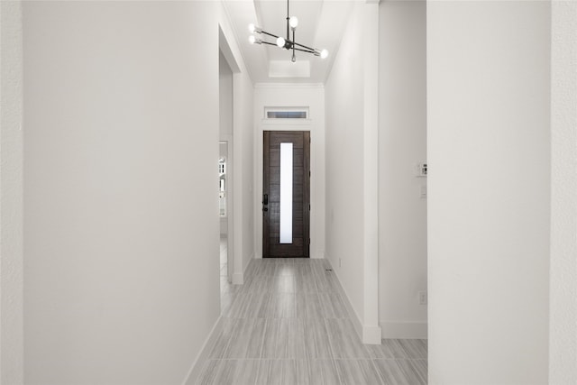 hallway with a chandelier and ornamental molding