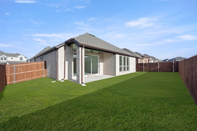 rear view of house with a yard and a patio area