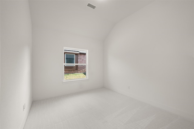 carpeted spare room featuring lofted ceiling