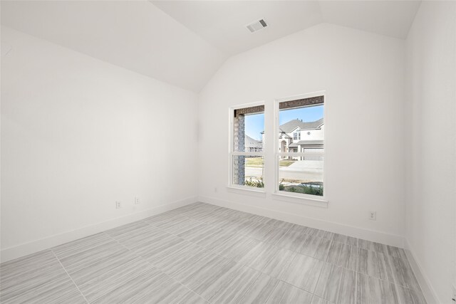 unfurnished room with vaulted ceiling