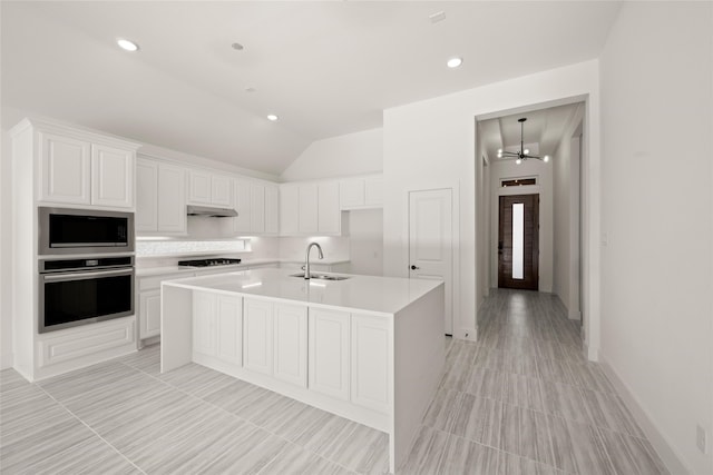 kitchen featuring white cabinetry, stainless steel appliances, sink, and a center island with sink