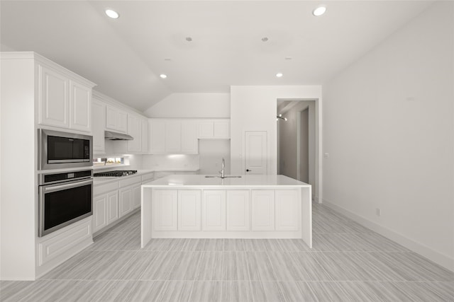 kitchen featuring lofted ceiling, sink, a center island with sink, appliances with stainless steel finishes, and white cabinets