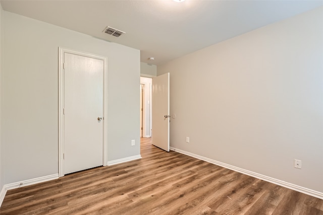 unfurnished bedroom with hardwood / wood-style flooring and a closet