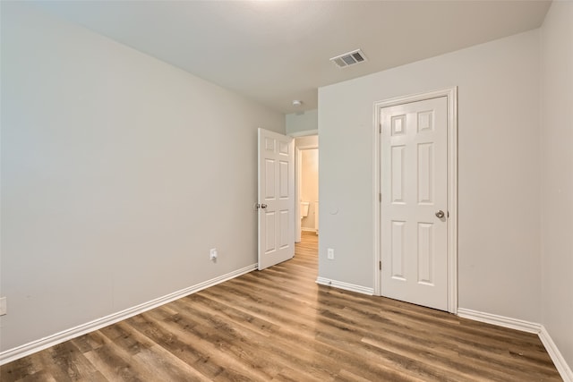 unfurnished bedroom with wood-type flooring and a closet