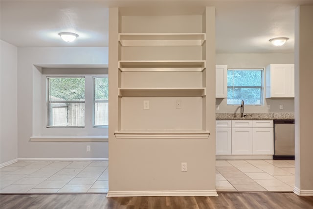 kitchen featuring a wealth of natural light, light wood-type flooring, and stainless steel dishwasher