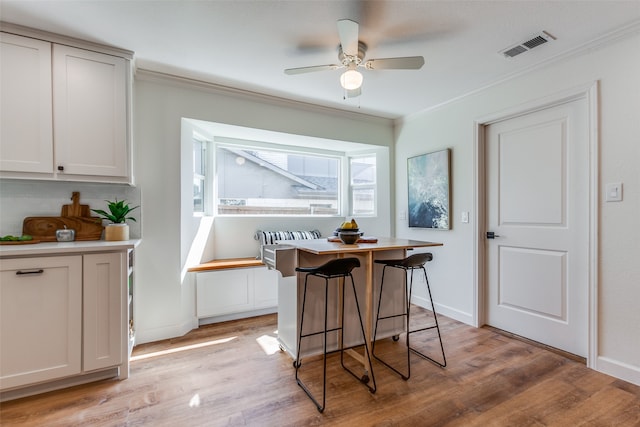 dining room featuring ceiling fan, light hardwood / wood-style flooring, and crown molding