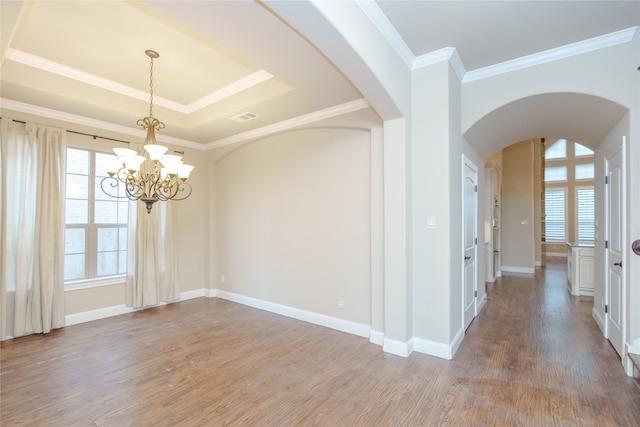 spare room featuring a notable chandelier, wood-type flooring, and plenty of natural light