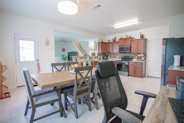 tiled dining space featuring ceiling fan