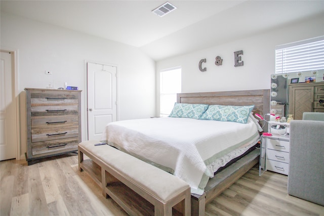 bedroom featuring light wood-type flooring and vaulted ceiling