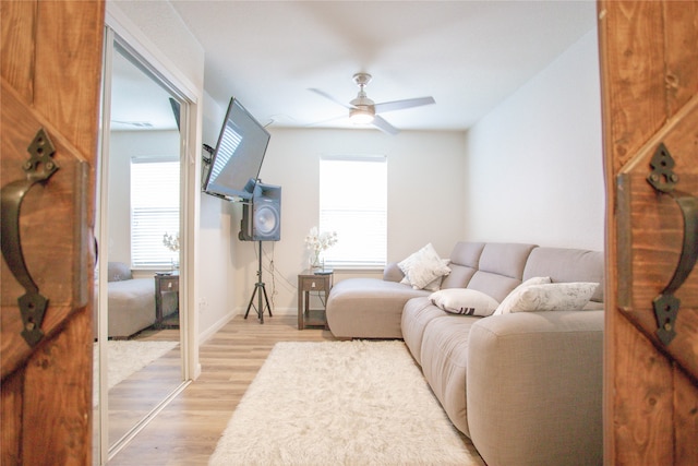 living room with light hardwood / wood-style flooring and ceiling fan