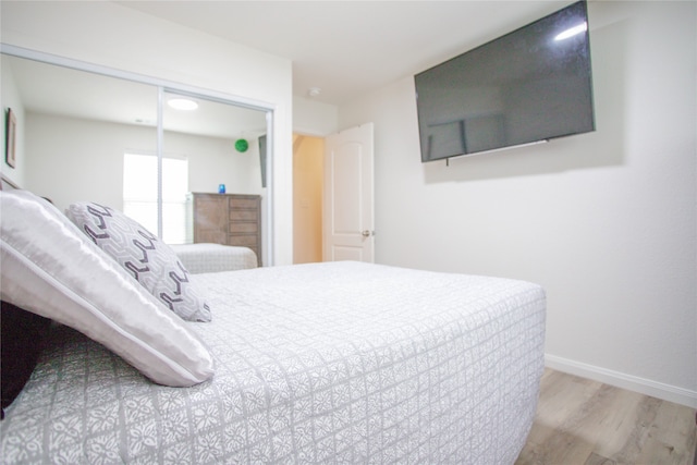 bedroom with light wood-type flooring and a closet