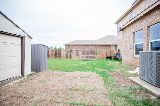 view of yard featuring a storage shed and central AC