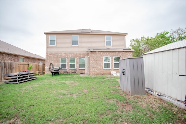 rear view of property with a storage shed and a yard