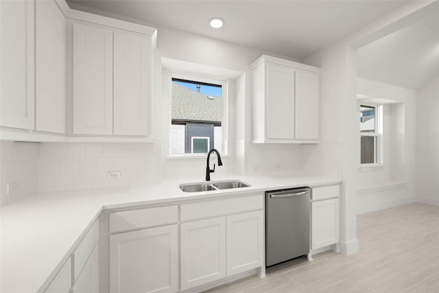 kitchen with white cabinetry, dishwasher, sink, and tasteful backsplash