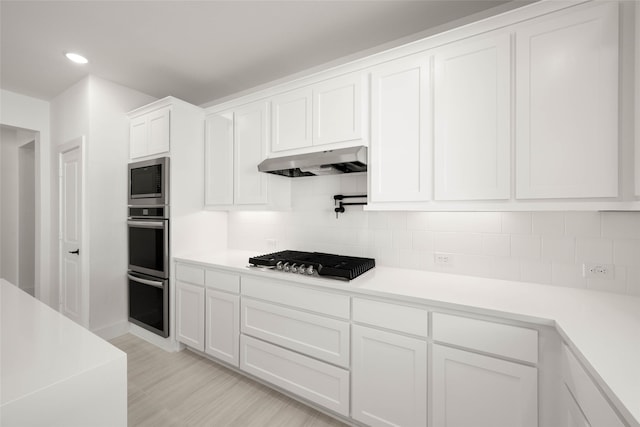 kitchen featuring white cabinetry, appliances with stainless steel finishes, and decorative backsplash