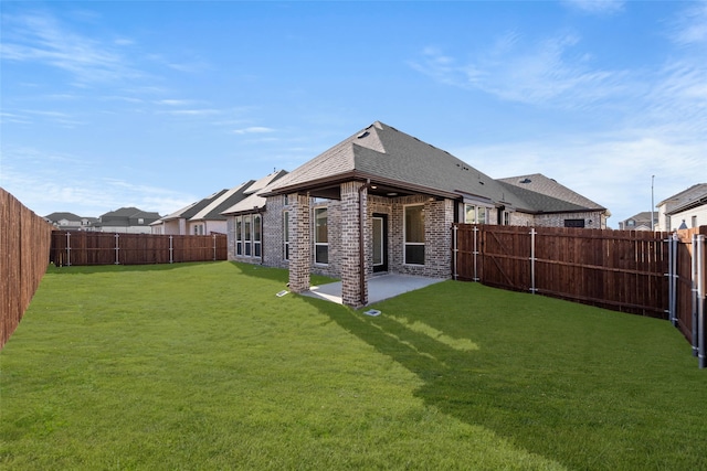 rear view of house featuring a yard and a patio