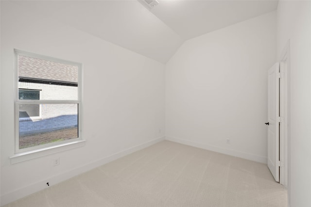 carpeted empty room with lofted ceiling