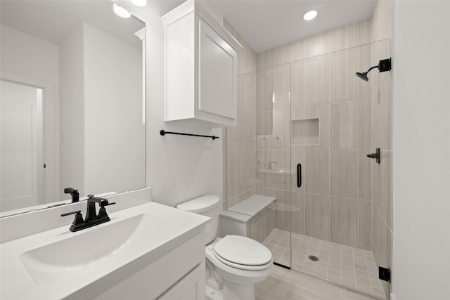 bathroom featuring vanity, toilet, and walk in shower